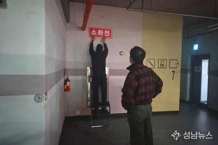 영동소방서 관계자가 아파트 지하주차장에 '보이는 소화전' 표지를 부착하고 있는 모습