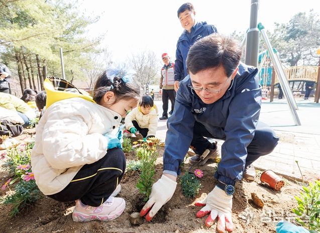 진교훈 서울 강서구청장(오른쪽)이 23일 방화근린공원에서 열린 ‘제81회 식목일 나무 심기 행사’에서 아이들과 꽃을 심고 있다.